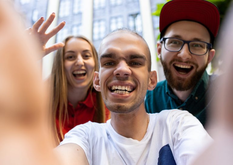 Three people looking at the camera smiling and celebrating.